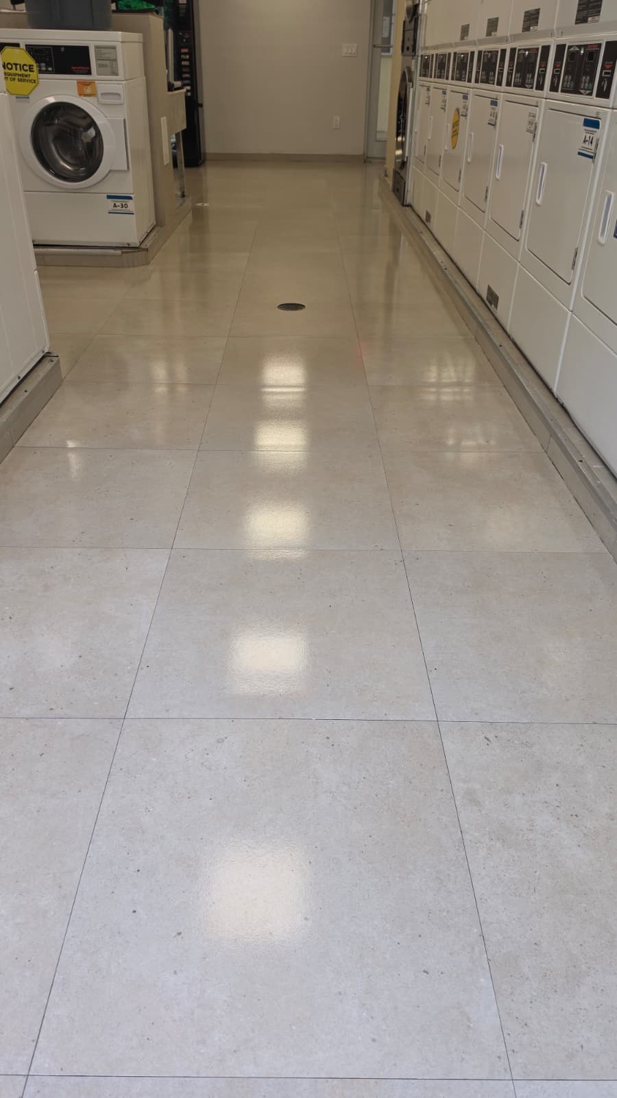 Ceramic floor coating on porcelain tile in a Miami laundry room, gloss finish along the dryers
